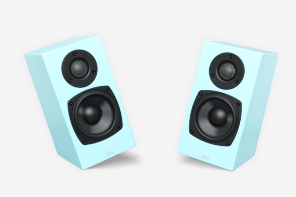 Two Totem Kin One bookshelf speakers in light blue featuring black circular drivers, each with a smaller tweeter on top and a larger woofer below, angled slightly towards each other against a white background.